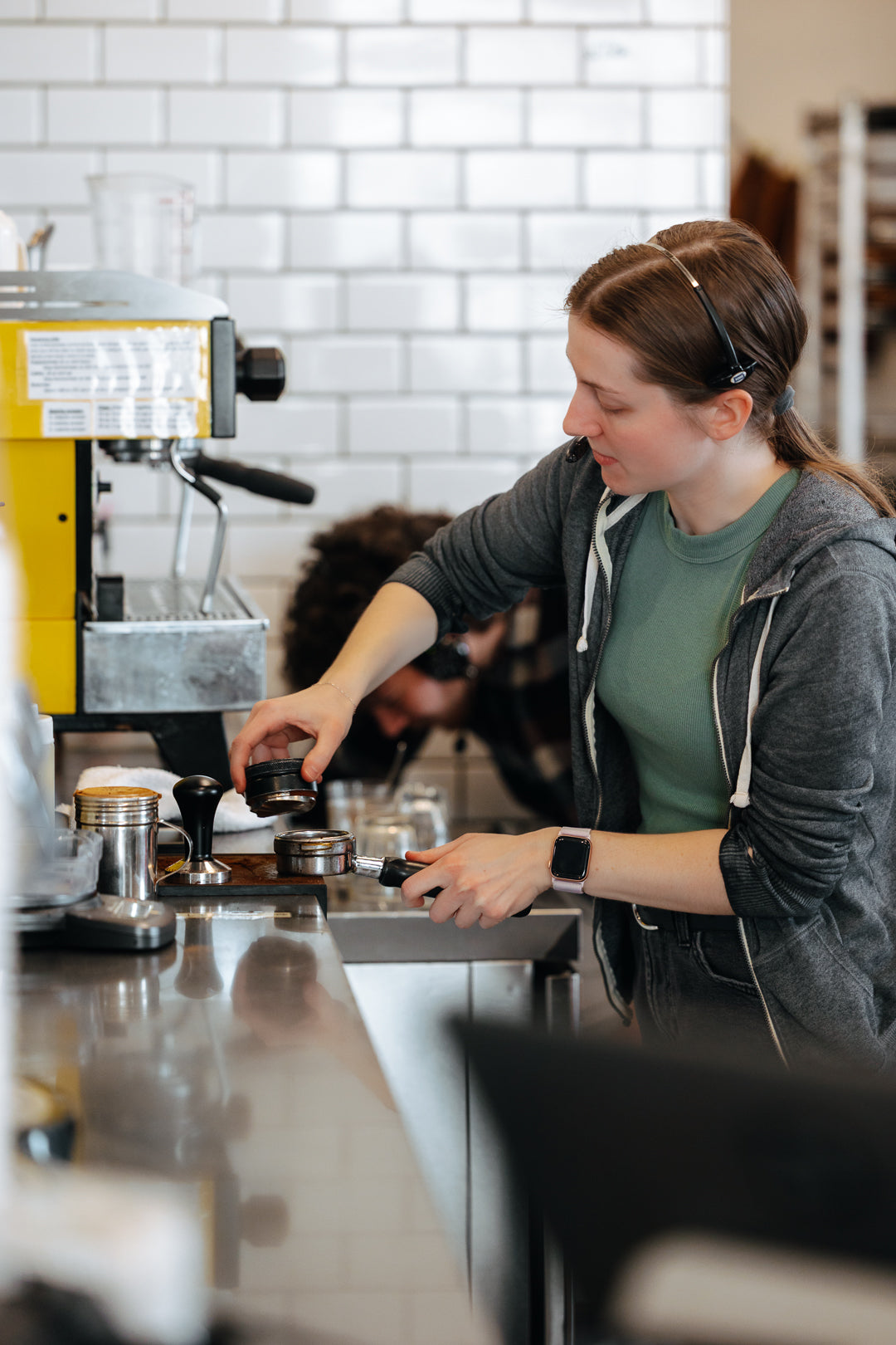 Mar 2026 barista at yellow espresso machine